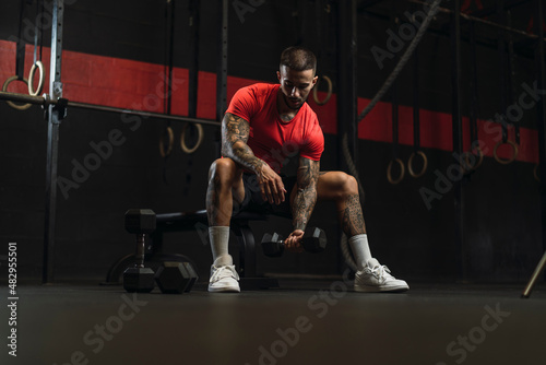 Chico musculoso con camiseta roja practicando deporte en un gym