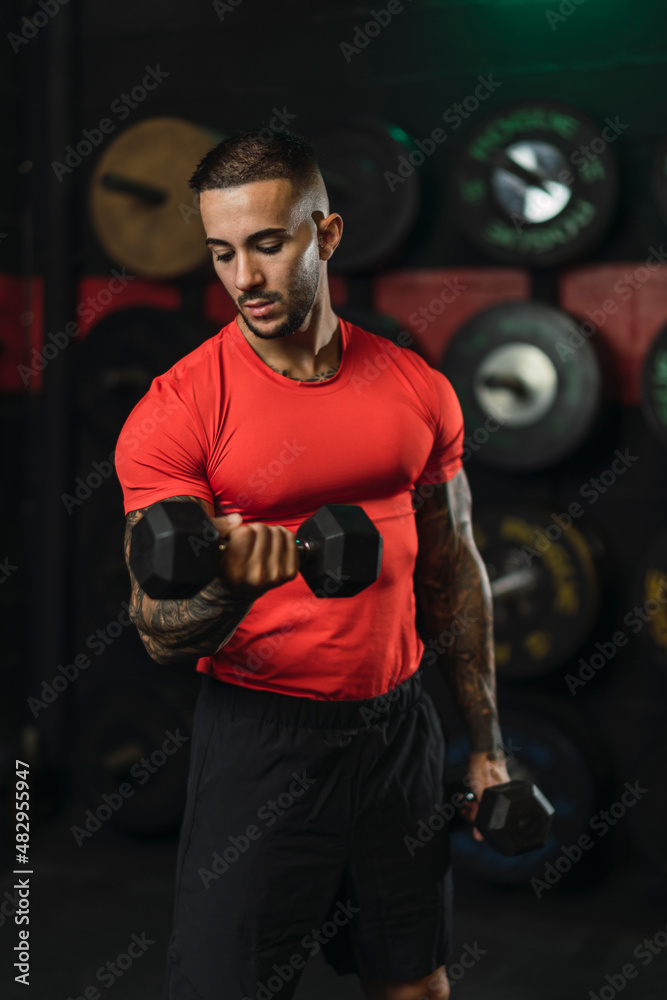 Chico musculoso con camiseta roja practicando deporte en un gym