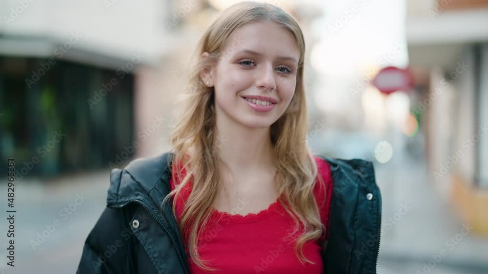 Young blonde girl smiling confident standing at street Young blonde girl smiling confident standing at street