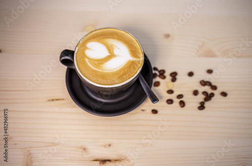 Espresso coffee with milk on table with wood background and coffee beans
