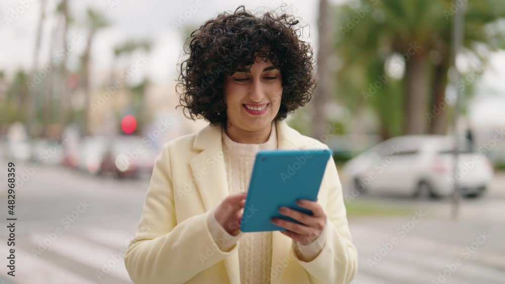 Young woman smiling confident using touchpad at street Young woman smiling confident using touchpad at street