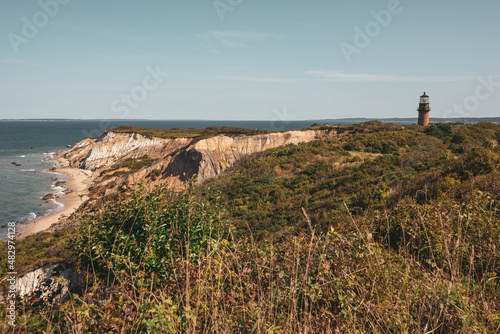 Gayhead lighthouse in Martha's Vineyard New England during sunny day on cliffside near ocean photo