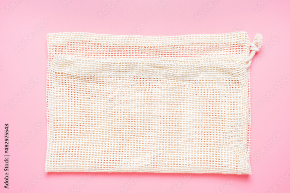 Cotton wicker eco bag on pink background close up top view. Cotton wicker eco bag on pink background close up top view.