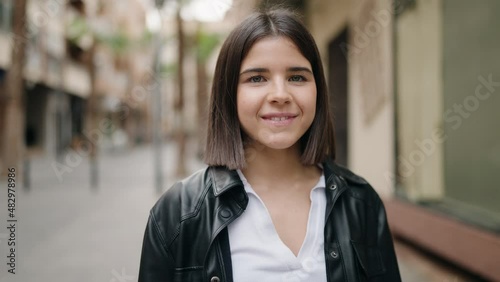 Young hispanic woman smiling confident standing at street photo