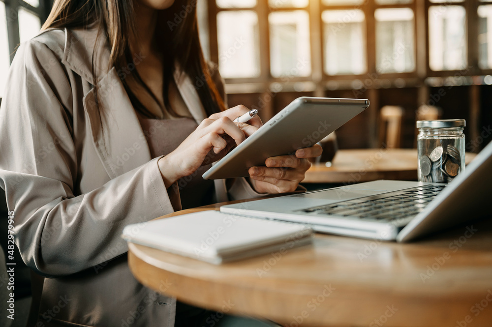 Confident businesswoman working on laptop and tablet at her workplace at modern office. Confident businesswoman working on laptop and tablet at her workplace at modern office.