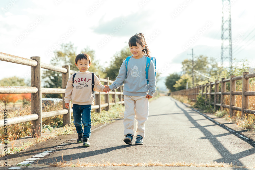 Fototapeta premium 手を繋いで笑顔をみせる子供 Innocent