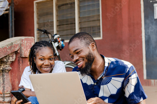 young african students using laptop and mobile phone to study online