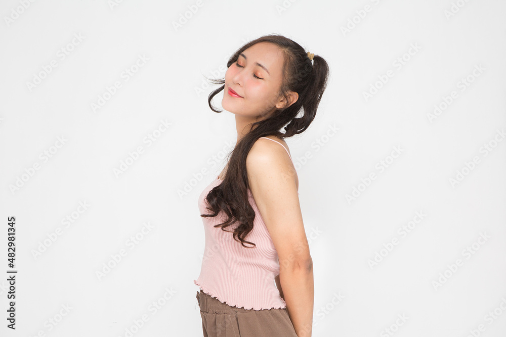 Beautiful Asian woman wearing pink casual shirt closing her eyes on white background and copy space.Cute Asian woman smiling and cheerful Beautiful Asian woman wearing pink casual shirt closing her eyes on white background and copy space.Cute Asian woman smiling and cheerful