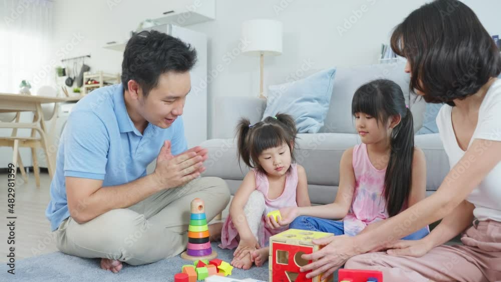 Asian young kid daughter coloring and painting on paper with parents. Asian young kid daughter coloring and painting on paper with parents.
