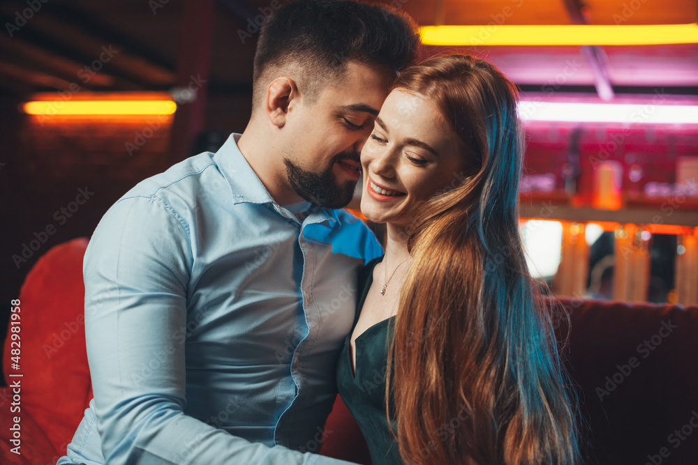 Young couple flirting at their first date at the restaurant. Valentine's Day. First kiss. Young couple flirting at their first date at the restaurant. Valentine's Day. First kiss.