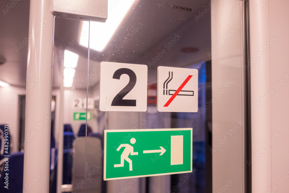 Signs in the modern train interior, exit, emergency brake, no smoking Signs in the modern train interior, exit, emergency brake, no smoking