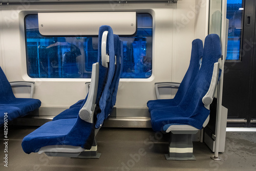 Modern train inside interior. Blue seats. Side view