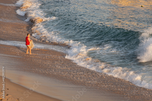 A person fishing with a net at Paciencia beach in Rio Vermelho neighborhood in Salvador, Brazil. photo