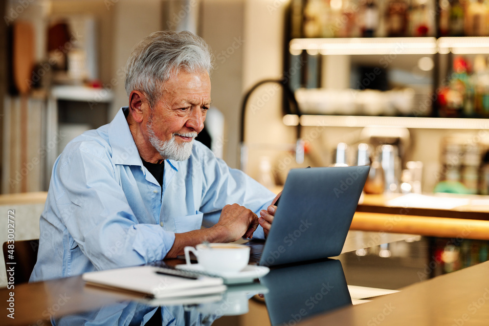 A smiling temporary senior student sitting in a cafe and having a video call in pause. Senior student study in the cafe. A smiling temporary senior student sitting in a cafe and having a video call in pause. Senior student study in the cafe.