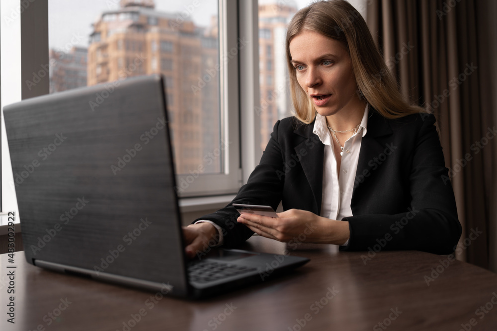Focused caucasian woman shopping online with laptop and credit card, business woman paying for an order in the office, ordering goods on the internet, online store purchases Focused caucasian woman shopping online with laptop and credit card, business woman paying for an order in the office, ordering goods on the internet, online store purchases