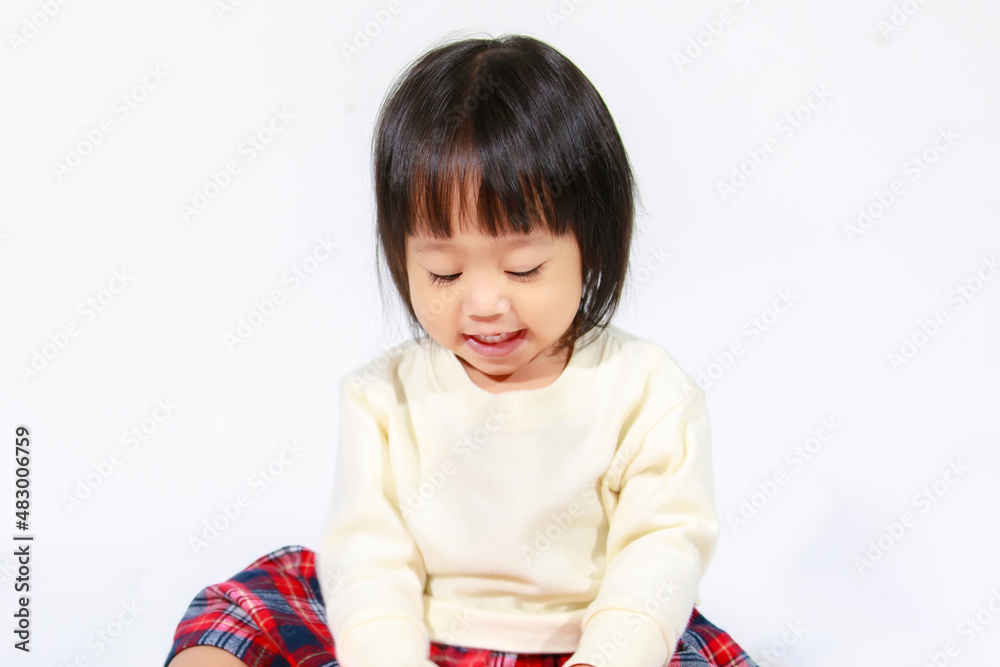 Studio shot of little cute short black hair Asian baby girl daughter model in casual plaid skirt sitting and smiling on white background Studio shot of little cute short black hair Asian baby girl daughter model in casual plaid skirt sitting and smiling on white background