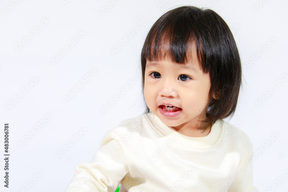 Studio shot of little cute short black hair Asian baby girl daughter model in casual plaid skirt sitting and smiling on white background Studio shot of little cute short black hair Asian baby girl daughter model in casual plaid skirt sitting and smiling on white background