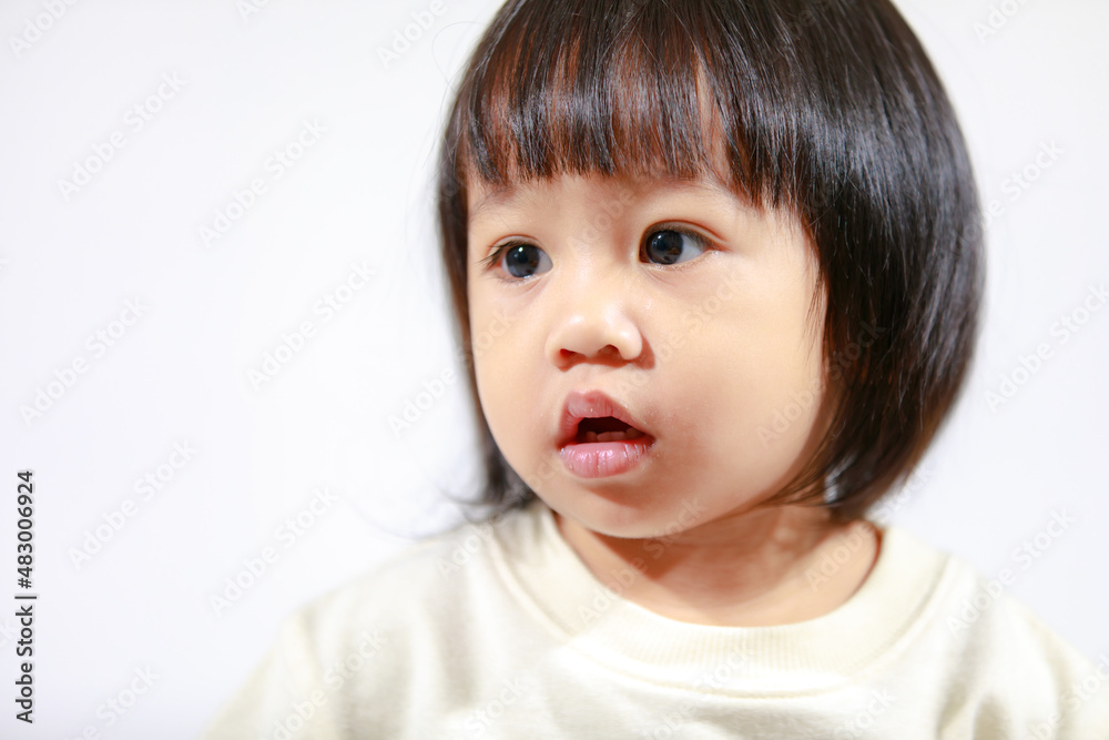 Studio shot of little cute short black hair Asian baby girl daughter model in casual plaid skirt sitting and smiling on white background Studio shot of little cute short black hair Asian baby girl daughter model in casual plaid skirt sitting and smiling on white background