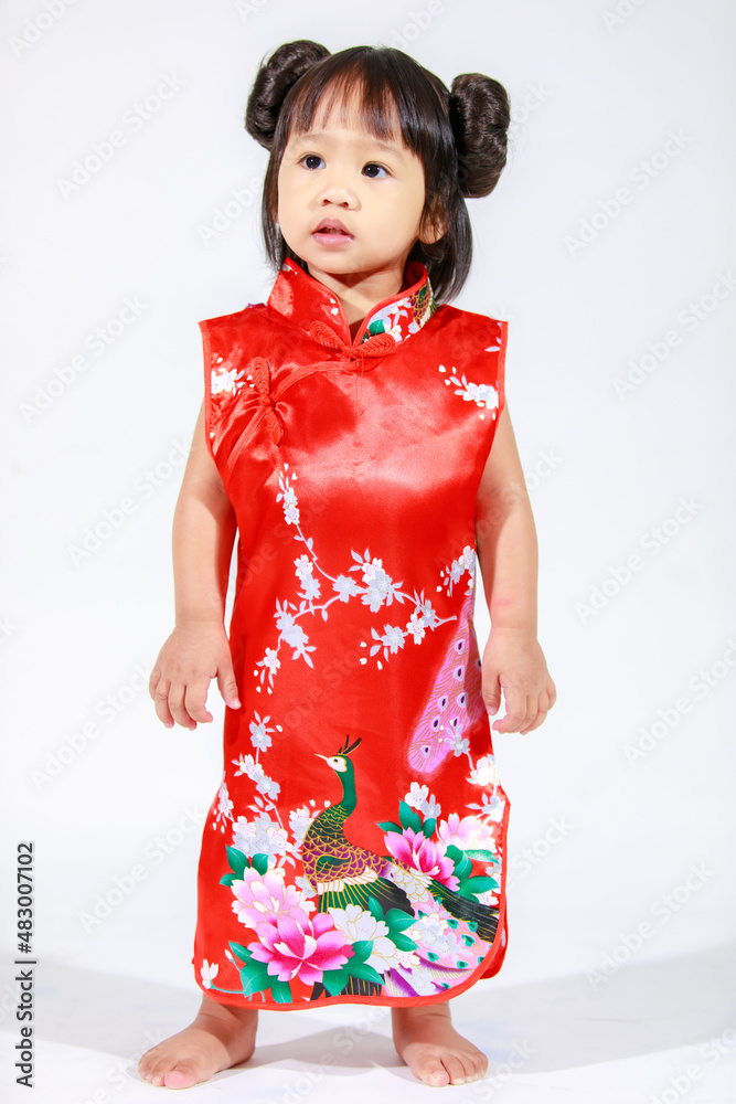 Studio shot of little cute innocent Asian kindergarten preschooler daughter girl kid model with bun hairstyle in red Chinese traditional qipao Cheongsam outfit standing alone on white background Studio shot of little cute innocent Asian kindergarten preschooler daughter girl kid model with bun hairstyle in red Chinese traditional qipao Cheongsam outfit standing alone on white background
