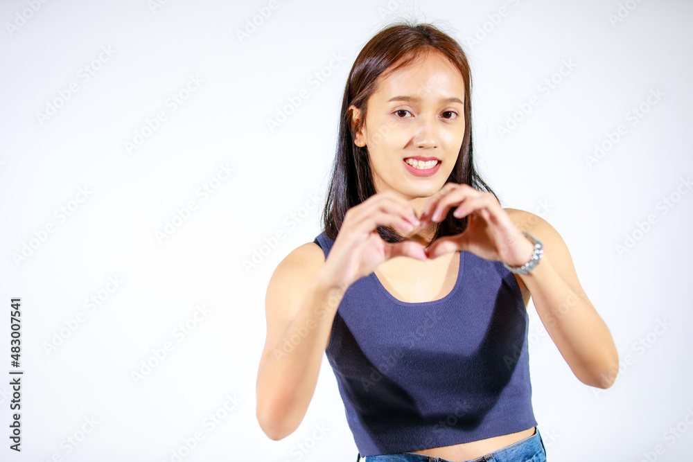 Isolated studio cutout shot of Asian young female model in crop top shirt and jeans standing holding hand pointing finger on blank space showing presenting product advertisement on white background Isolated studio cutout shot of Asian young female model in crop top shirt and jeans standing holding hand pointing finger on blank space showing presenting product advertisement on white background