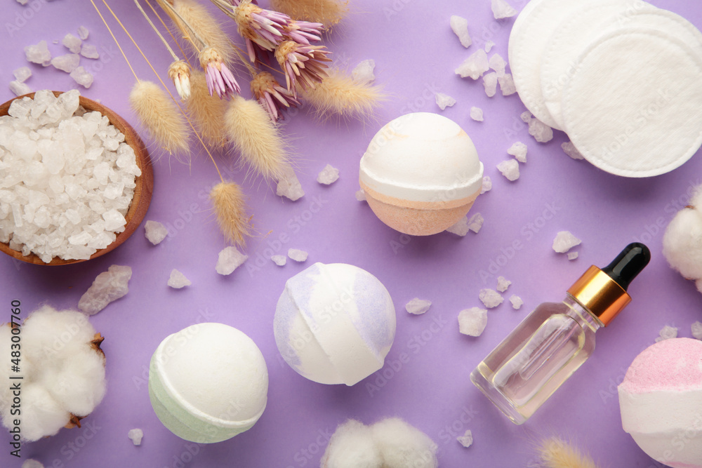 Aroma bath bombs in spa composition with dry flowers and salt on purple background. Vertical photo Aroma bath bombs in spa composition with dry flowers and salt on purple background. Vertical photo