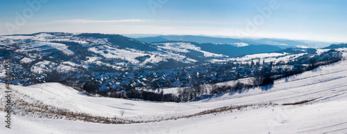 panoramic landscape with a village between hills in winter © sebi_2569