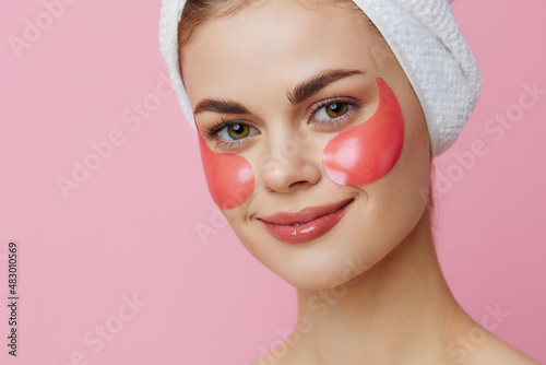 woman skin care face patches bare shoulders pink background