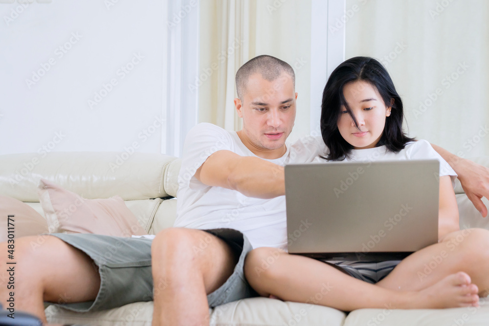 Happy couple using a laptop computer at home Happy couple using a laptop computer at home