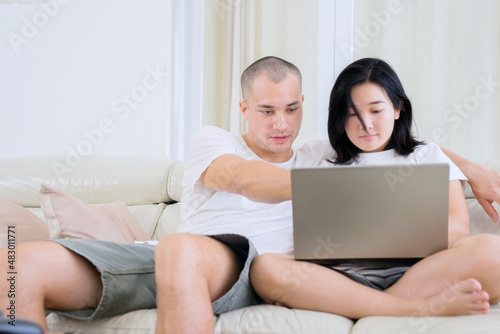 Happy couple using a laptop computer at home