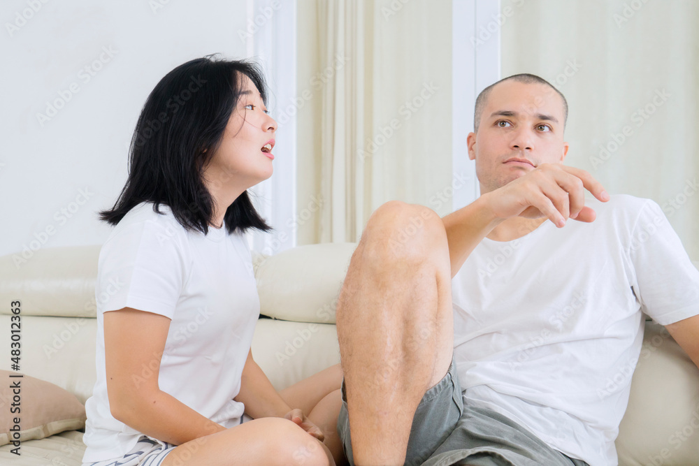 Woman blaming her husband while arguing at home Woman blaming her husband while arguing at home