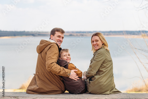 young happy family sitting with beautiful lake view