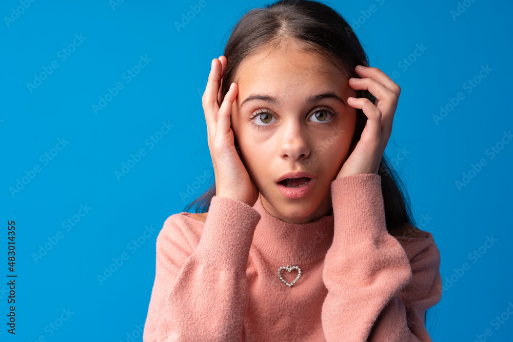 Shocked and surprised young teen girl against blue background Stock ...