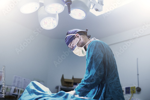 Carefully does it. Shot of a focused young surgeon performing surgery on a patient in an operating room.