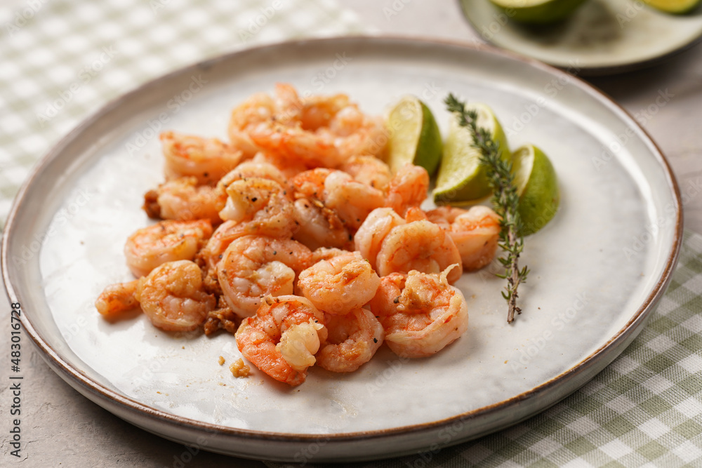 Grilled shrimps or tiger prawns served with lime, garlic and fresh herbs on scandi round plate on concrete surface. Pescatarian protein nutrition Grilled shrimps or tiger prawns served with lime, garlic and fresh herbs on scandi round plate on concrete surface. Pescatarian protein nutrition