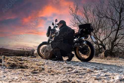 Sunset background with motorcycle and biker relaxing