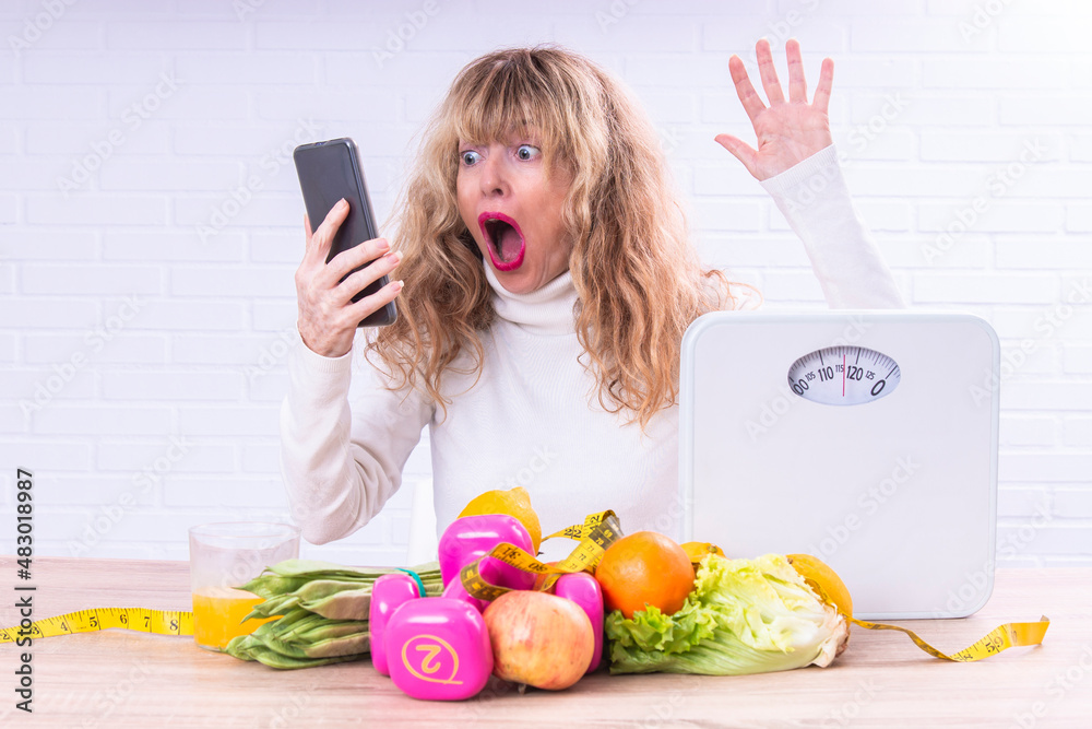 woman with phone and scale with expression of surprise. diet and technology concept woman with phone and scale with expression of surprise. diet and technology concept