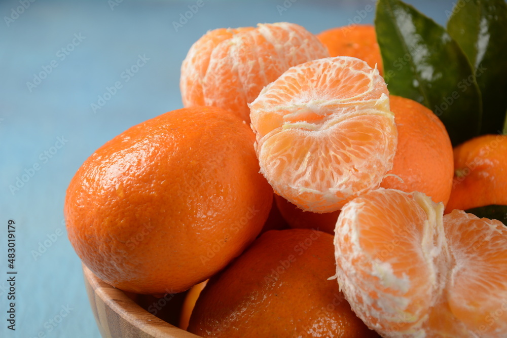 Fresh mandarin fruit with leaves from the orchard. Home gardening. Organic mandarin whole and slices. Orange color. Fresh mandarin fruit with leaves from the orchard. Home gardening. Organic mandarin whole and slices. Orange color.