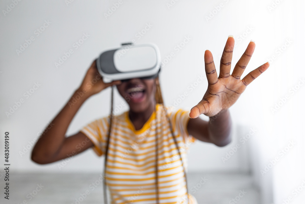 Excited black lady using VR glasses, grabbing something Excited black lady using VR glasses, grabbing something