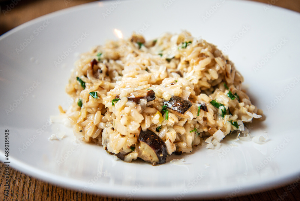 Delicious Italian vegetarian risotto cooked with mushrooms and onions served in white plate. Delicious Italian vegetarian risotto cooked with mushrooms and onions served in white plate.