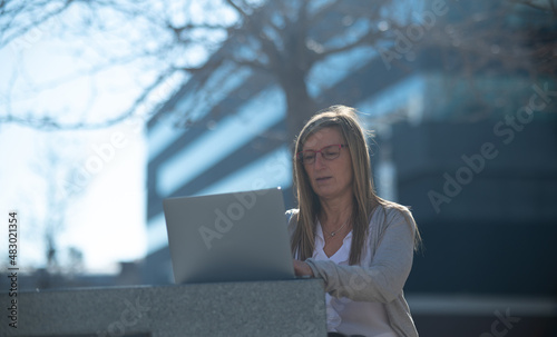 Woman with laptop outdoors in an office space