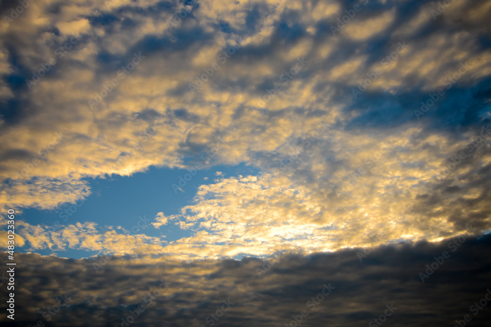 Fototapeta premium blue sky with golden fluffy clouds and sun