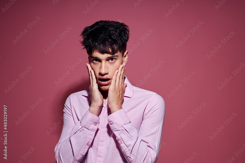 pretty man in a pink shirt gesturing with his hands pink background unaltered pretty man in a pink shirt gesturing with his hands pink background unaltered