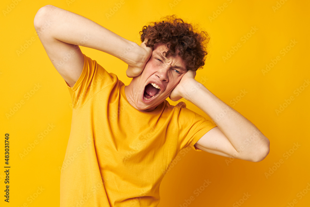 cute red-haired guy yellow t-shirt fashion hand gestures yellow background unaltered cute red-haired guy yellow t-shirt fashion hand gestures yellow background unaltered