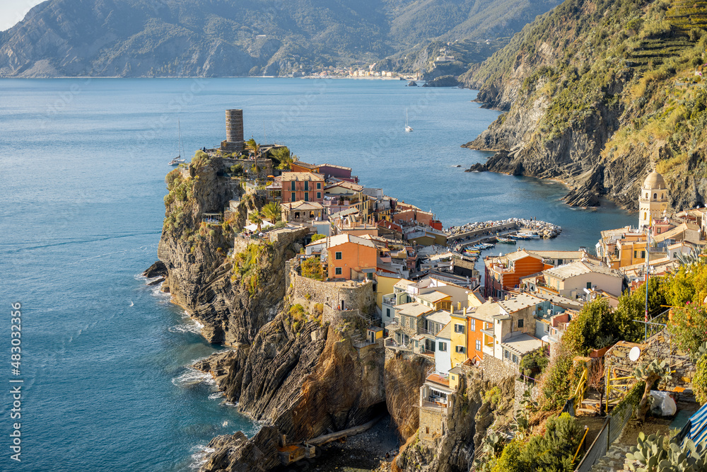 Landscape of coastline with Vernazza village in Italy on sunny day. Famous town in Cinque Terre region in northwestern Italy. Traveling italian landmarks concept