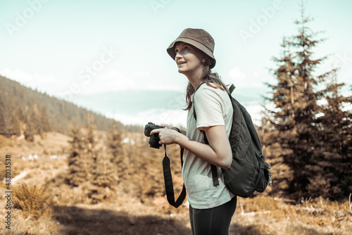 Young female tourist hold in hands take photography photo camera on the top of mountain. Journey landscape vacation concept
