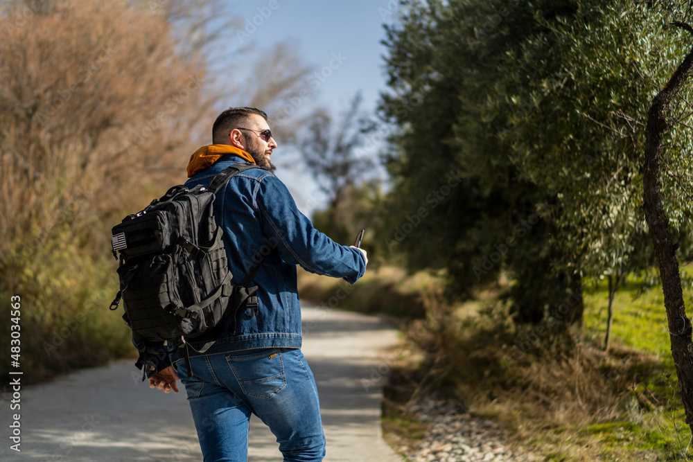 Chico alto con barba de senderismo por paraje natural en andalucia