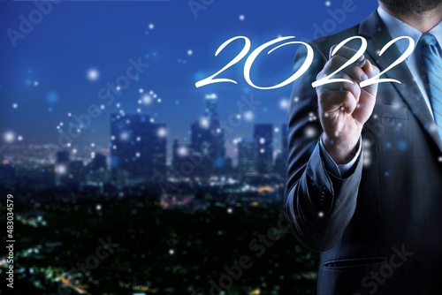 Smart businessman pointing digital dashboard in 2022 on hologram background.