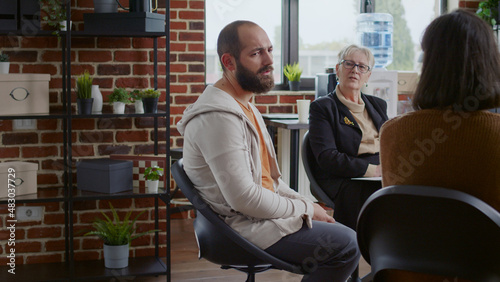 Frustrated man sharing story with group of people and therapist at aa therapy meeting. Person sitting in circle, talking about mental health problems and breakdown with psychiatrist.