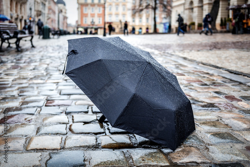 umbrella standing on wet stone pavement © Volodymyr Shevchuk