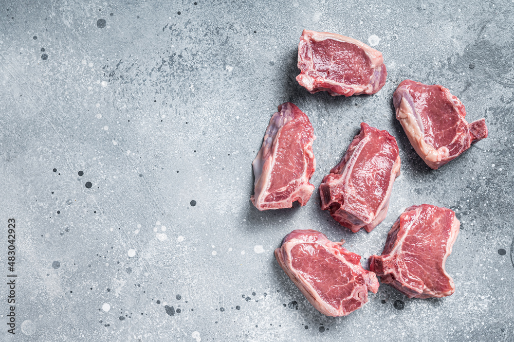Raw fresh lamb loin chops cutlets. Gray background. Top view. Copy space